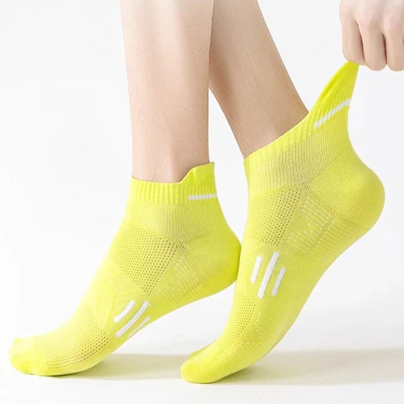 A pair of neon yellow breathable running socks worn on a person's foot.