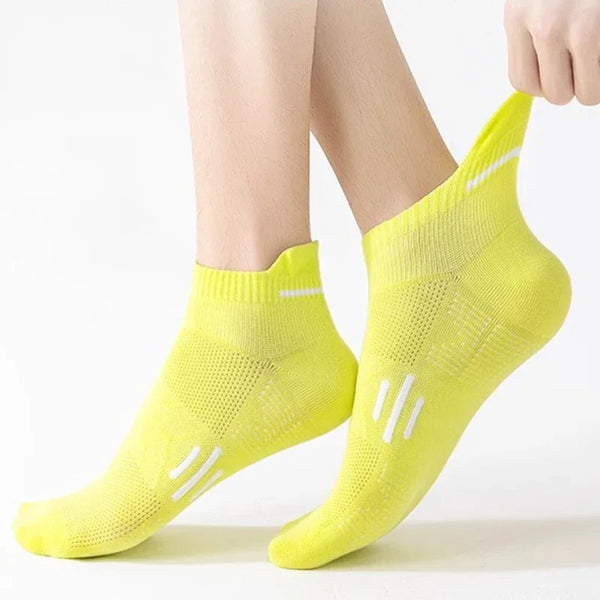 A pair of neon yellow breathable running socks worn on a person's foot.