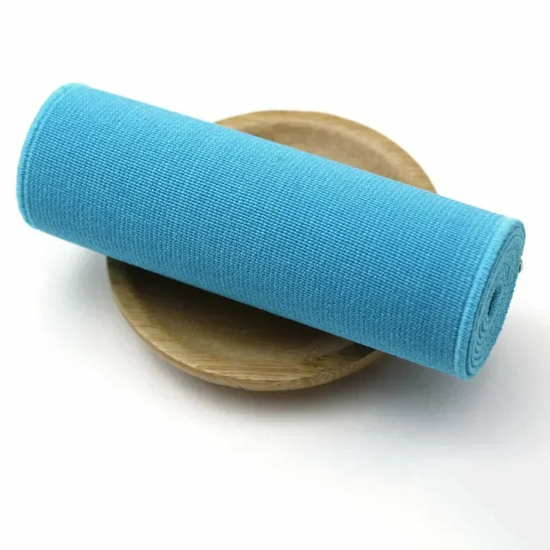 A roll of bright blue elastic bands resting on a wooden surface.