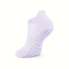 A pair of white grip pilates socks designed for yoga and barre.