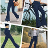 A woman wearing dark blue high-waisted yoga leggings with flare details is shown outdoors.
