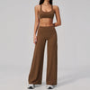 A woman wearing a brown two-piece yoga and sports tracksuit set consisting of a cropped top and matching long pants.