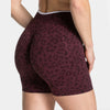 A pair of maroon leopard print seamless yoga shorts worn by a person.