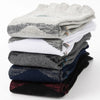 A stack of men's sport compression socks in various shades of gray, blue, and black.