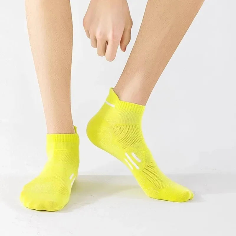 A bright yellow pair of premium breathable men's running socks worn on a person's foot.