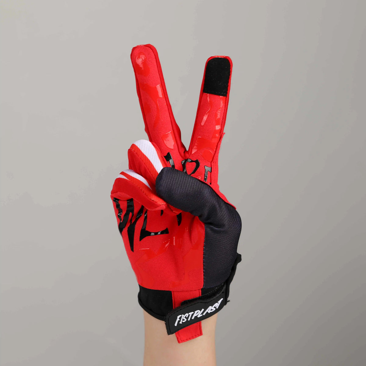 A close-up of a red cycling riding glove with black accents and white lining.