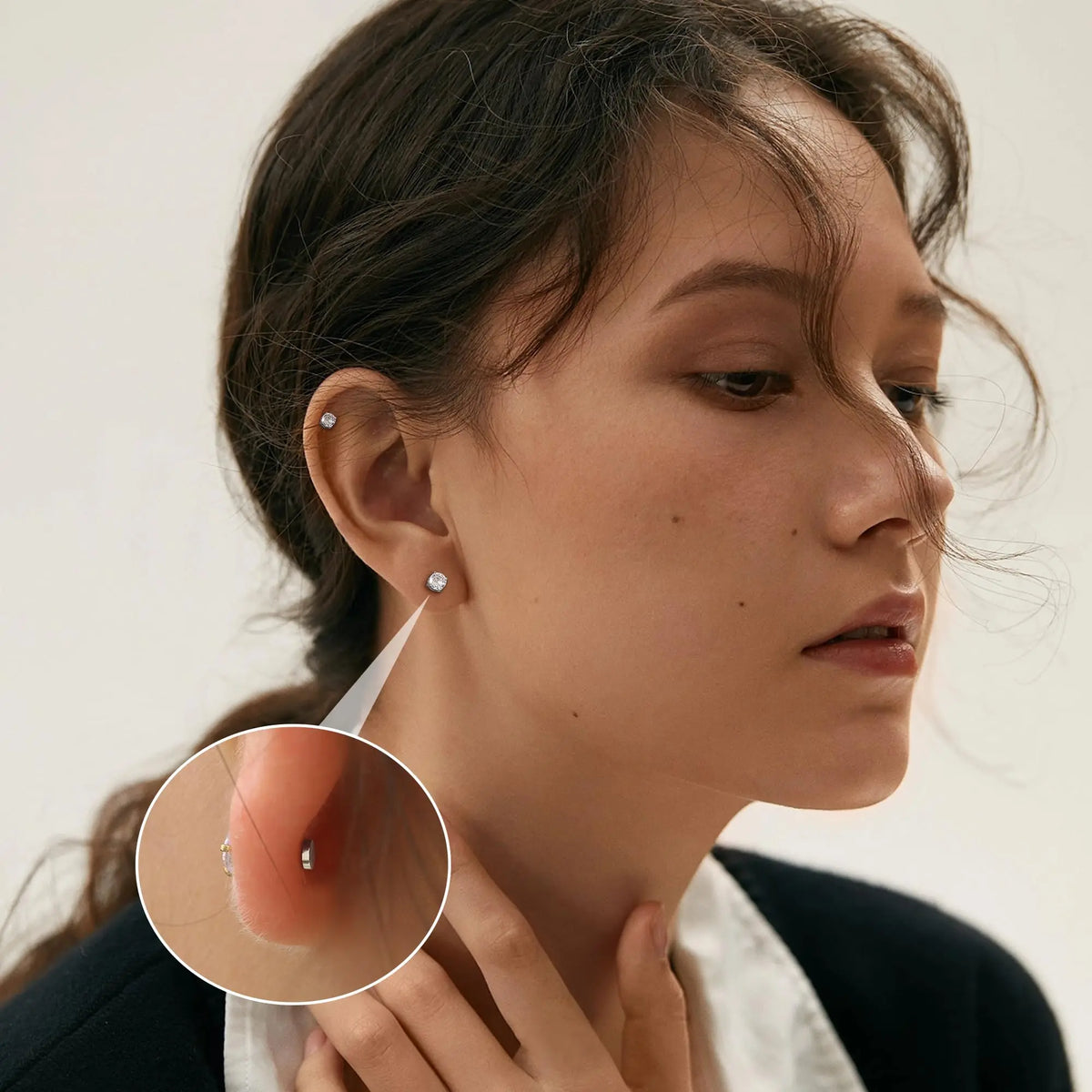 Close-up of a woman wearing magnetic cubic zirconia stud earrings on her ear.