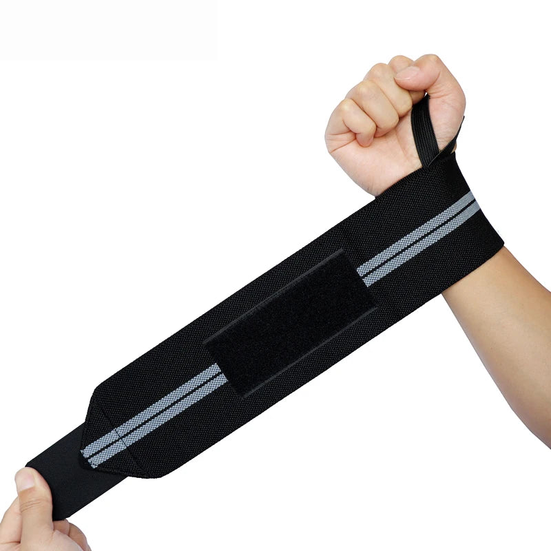 Black wrist wraps with silver stripes being held by a hand.