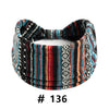 A black, blue, and red striped knitted headband with a polka dot pattern.