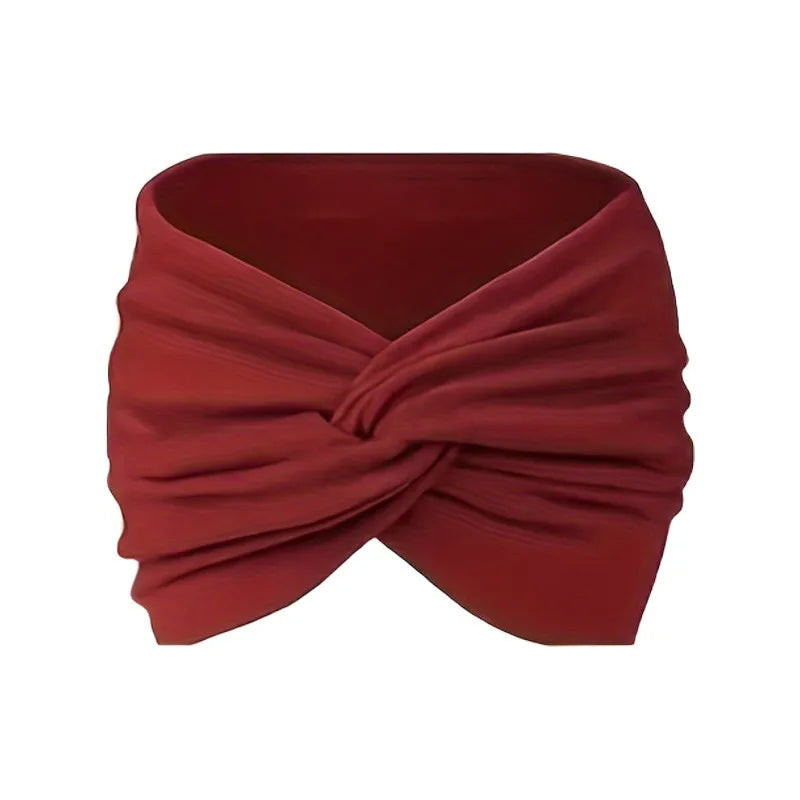 A maroon stretch sport headband wrapped around itself, shown flat.