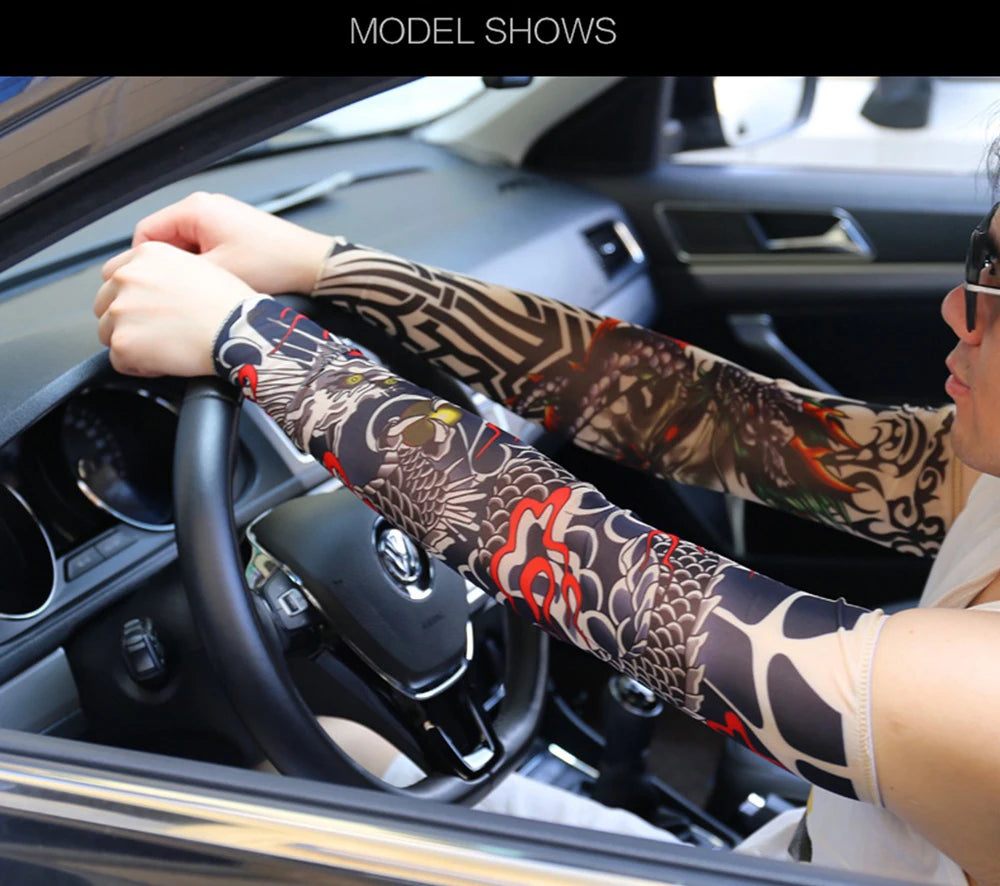 A person wearing patterned tattoo arm sleeves is driving a car, with the interior visible through the windshield.