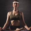A woman wearing a white sports headband is shown in a fitness pose against a dark background.