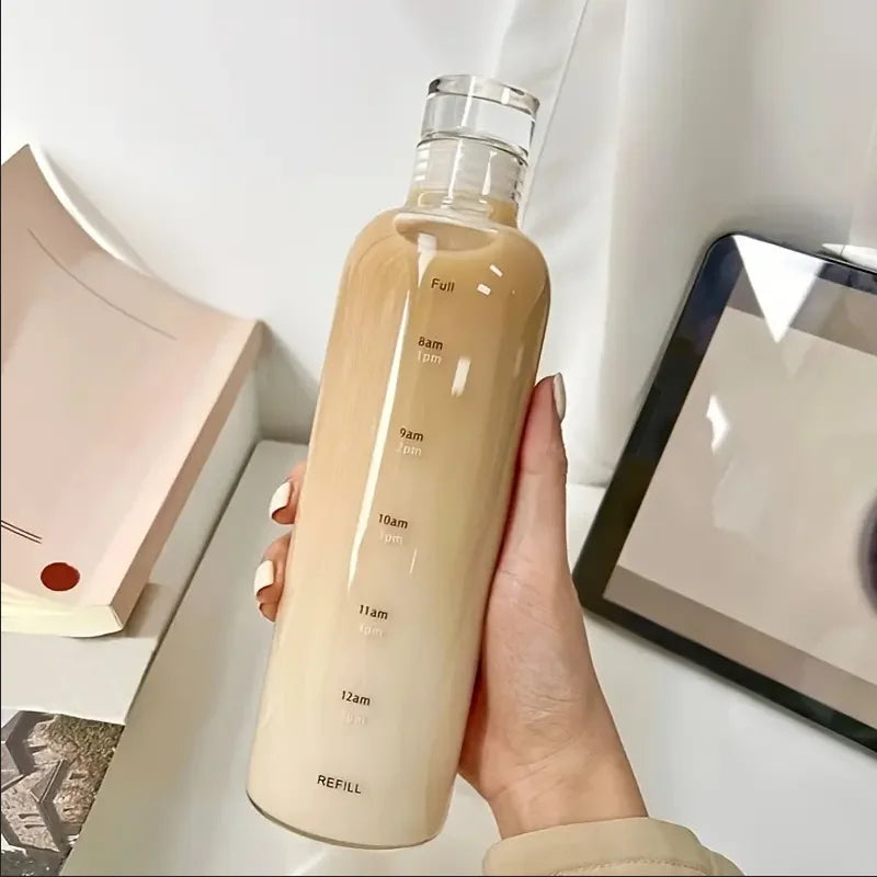 A tall, beige insulated water bottle with a time scale marking 8 am to 12 am is held in a person's hand.