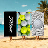 Three people holding large white golf balls against a tropical beach background.