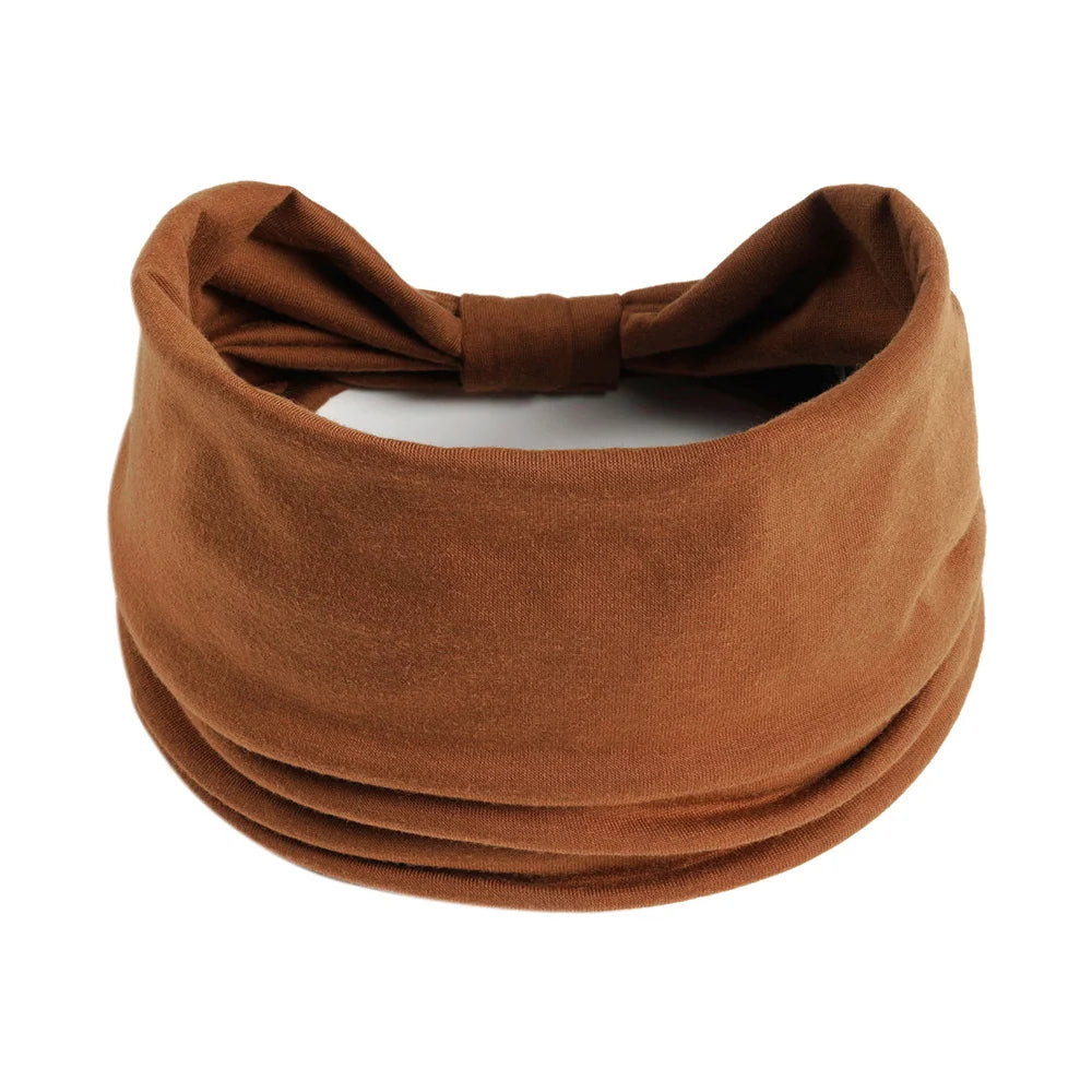 Un foulard en tissu brun noué en nœud, utilisé pour les cheveux et la coiffure.