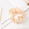 A light peach satin scrunchie is displayed on a white background next to a ruler and text.