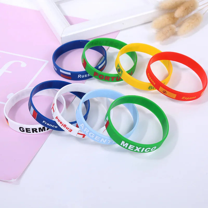 A collection of multi-country silicone wristbands in various colors including blue, green, yellow, and red.