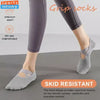 Gray silicone grip socks shown on a foot, designed for skid resistant traction during workouts.