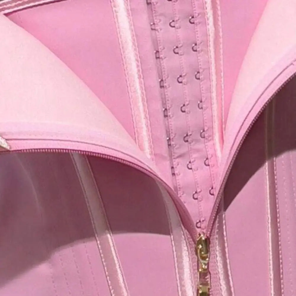 Gros plan sur un corset de gaine rose sans couture avec coutures et fermeture éclair visibles.