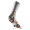 A close-up view of white athletic socks with orange and gray patterned designs.