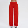 A full-length shot of a woman wearing red high-waist flared yoga pants.