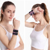A woman wearing a black and pink adjustable wrist support brace on her wrist.