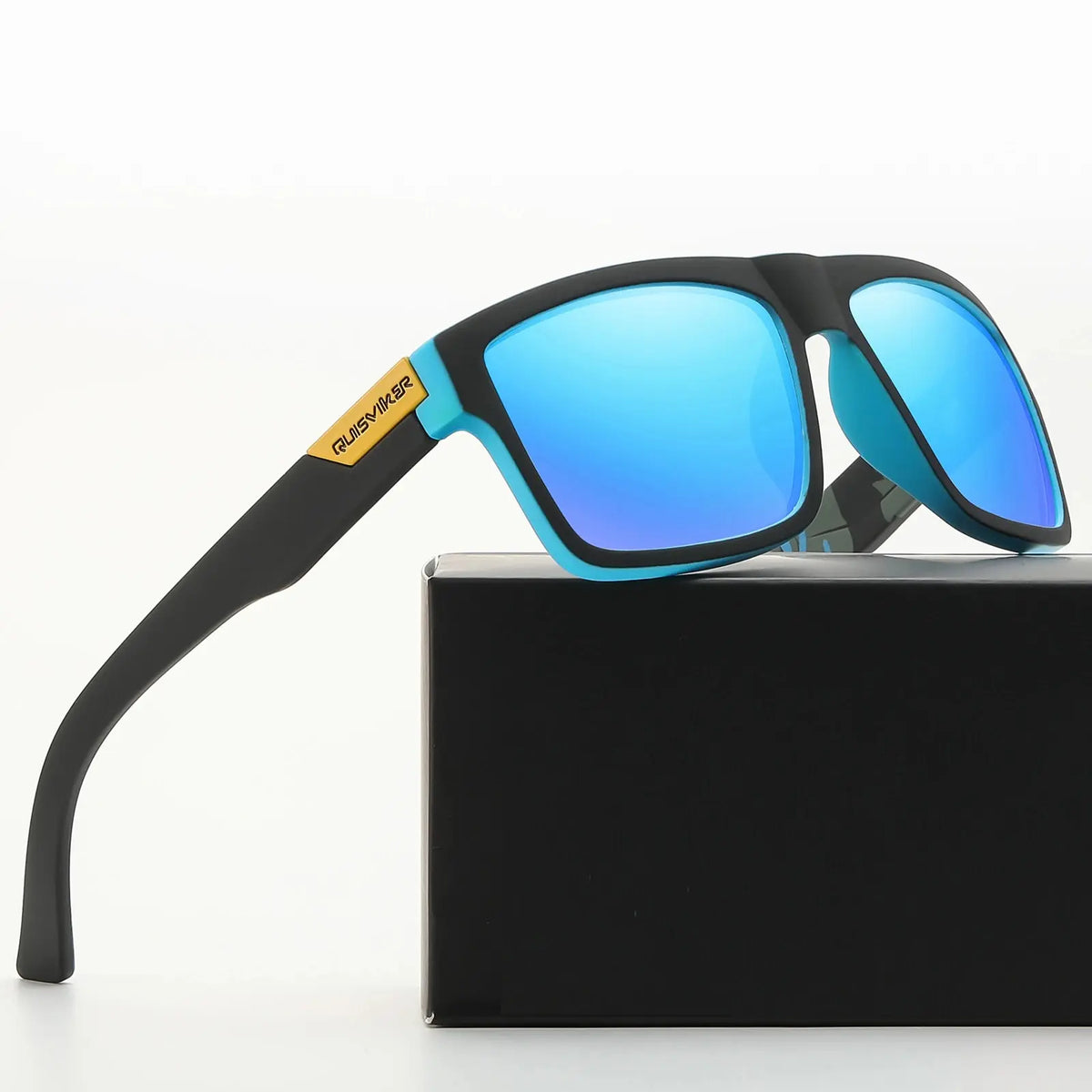 Un par de gafas de sol polarizadas para pescar, negras y azules, sobre una caja negra.