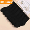 Une pile de vingt paires de chaussettes de sport noires à mi-mollet pour femmes, en tricot respirant, sur un fond clair.