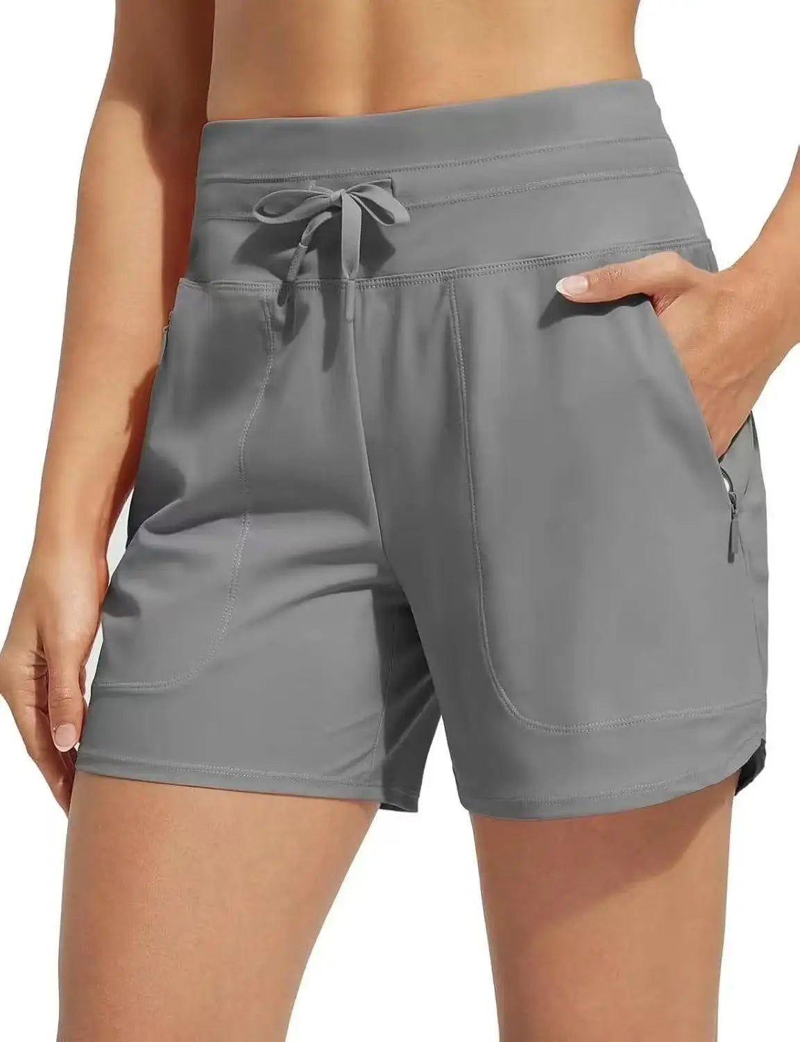 A model is wearing gray high-waisted quick-dry athletic shorts with a drawstring waist.