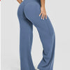 A model is wearing high waisted blue yoga pants while standing.