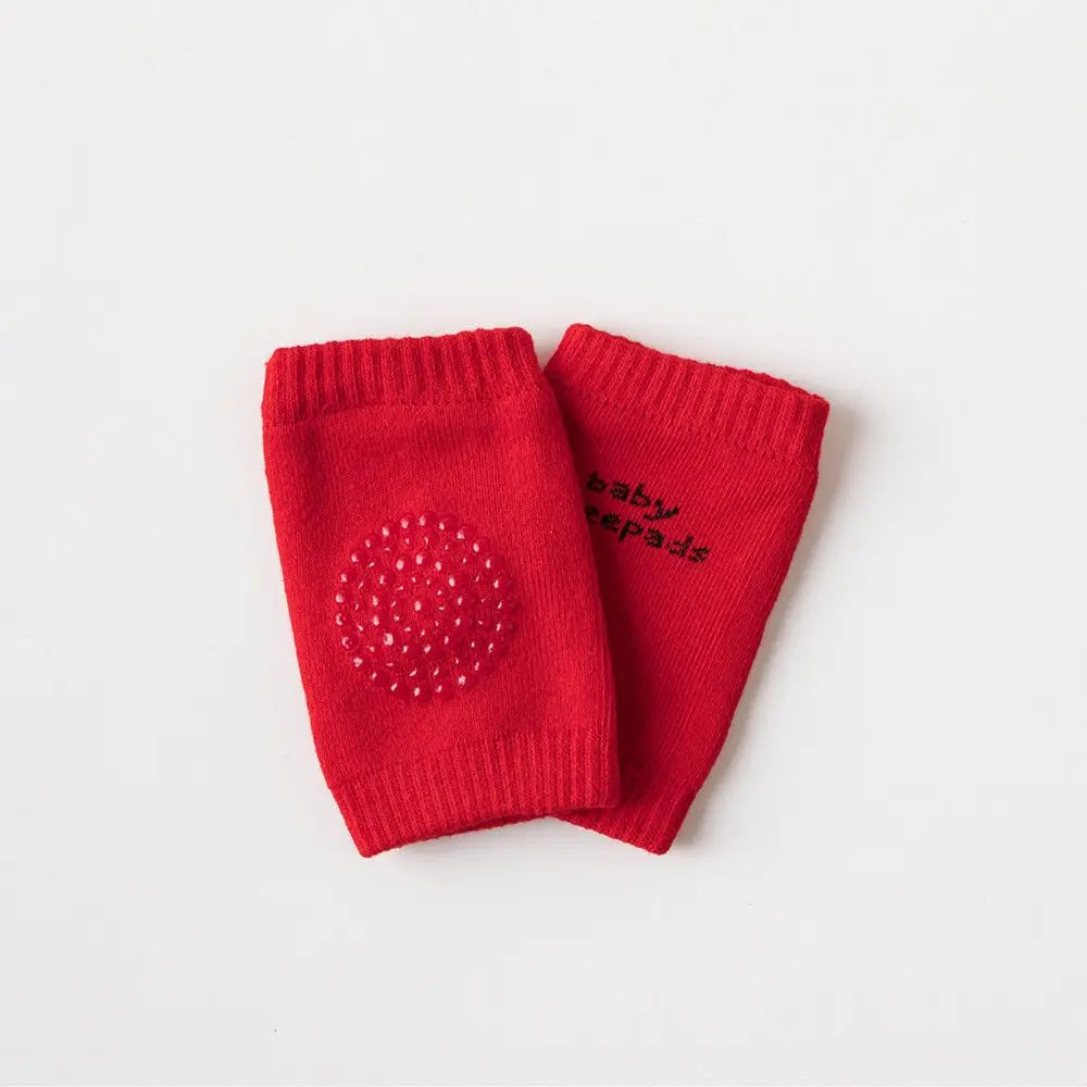 Ein Paar rote Strickknöchelschutzpolster für Kleinkinder beim Krabbeln.