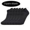 Three pairs of black performance running socks laid out in a row.