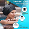 A woman wearing a black silicone swimming cap, demonstrating how to put it on and covering her ears.