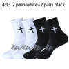 A collection of white and black sports socks featuring a cross design for prayer and Christian use.