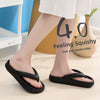 A pair of black comfort platform flip flops shown on a person's foot.