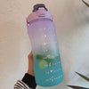 Una mano sostiene una botella de agua aislada morada y motivacional con tapa de pajita, con recordatorios basados en el tiemp