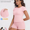 A woman models a pink sports casual tracksuit top and shorts, highlighting dual side pockets.