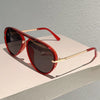 Red-framed vintage pilot gradient sunglasses resting on a light surface.