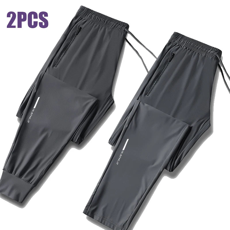 Two pairs of men's ice silk performance pants in gray fabric shown flat