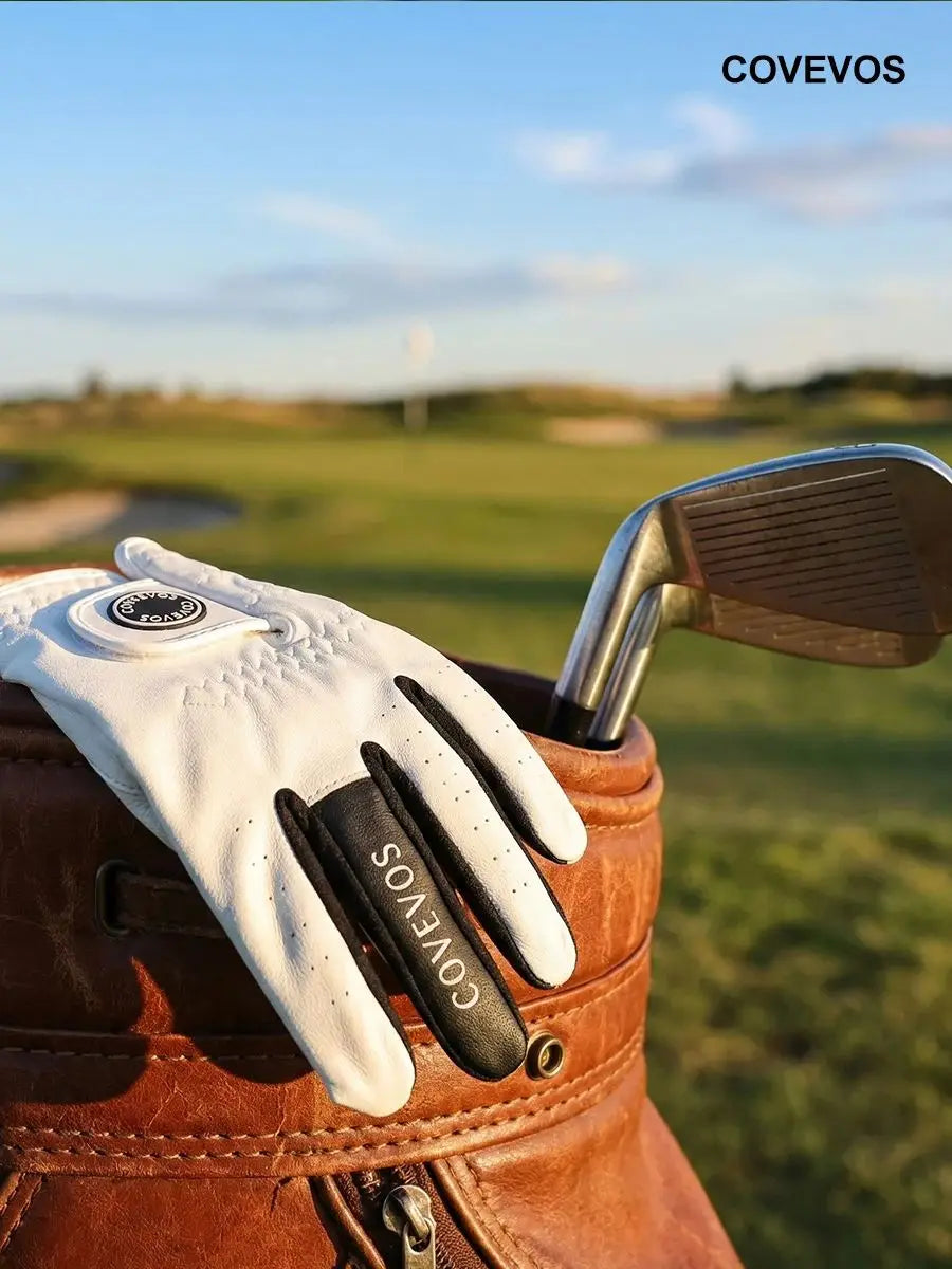 Gant de golf en cuir marron Covevos posé sur un club de golf.