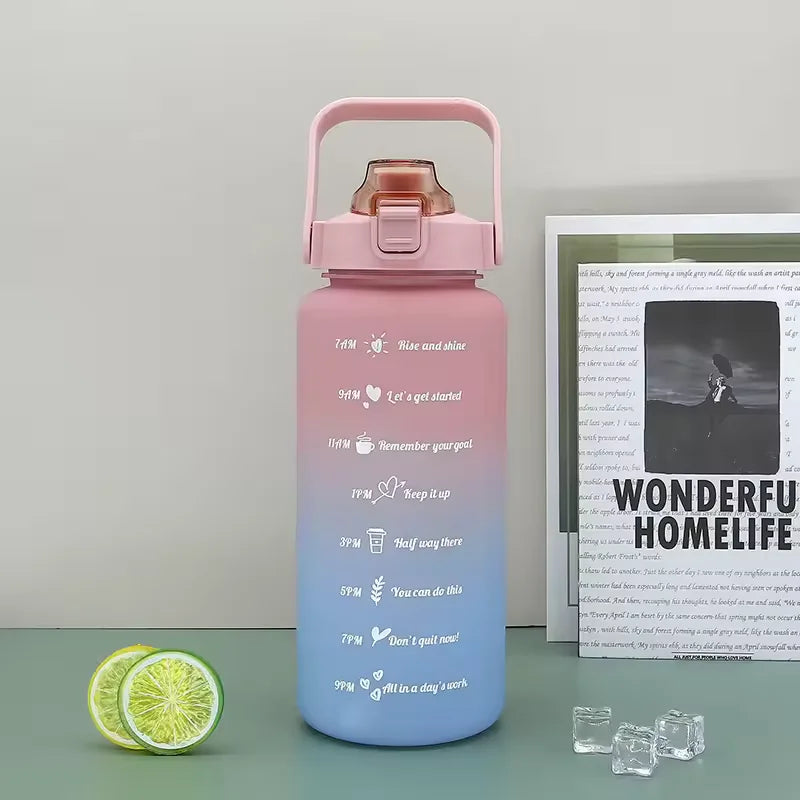 A pink sports water bottle with a straw and motivational text is shown next to sliced lime wedges.