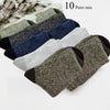 Ten pairs of mixed colored merino wool hiking socks displayed in a pile.