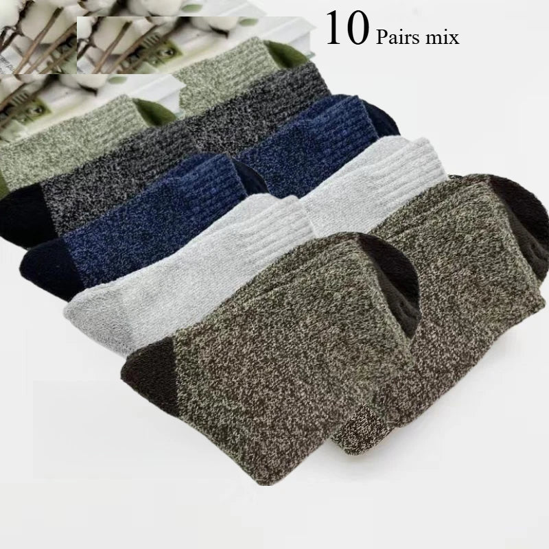 Ten pairs of mixed colored merino wool hiking socks displayed in a pile.