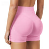 Une femme porte des shorts de yoga sans couture à taille haute de couleur rose pâle.