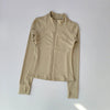 A beige long-sleeved zip-up jacket for yoga and fitness.