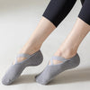 Gray non-slip yoga and gym socks with silicone grip worn on a person's foot.