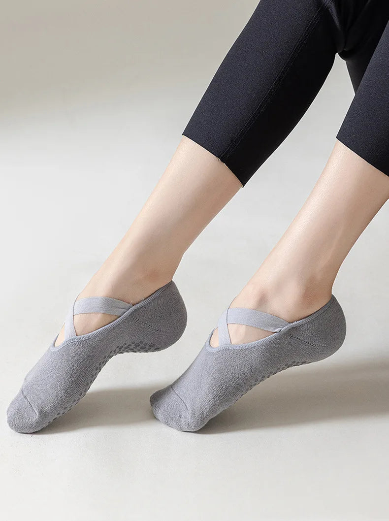 Gray non-slip yoga and gym socks with silicone grip worn on a person's foot.