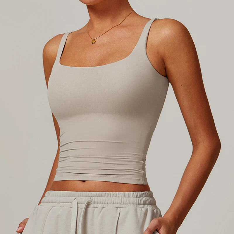 Modelo vistiendo un top deportivo de cuello cuadrado beige claro y la parte inferior a juego.