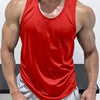 A muscular man wearing a red sleeveless tank top and light gray athletic pants.