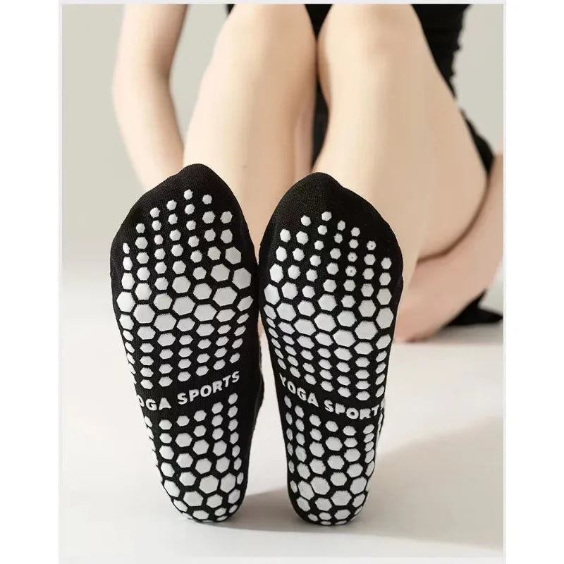 Pair of black non-slip grip socks with a white honeycomb pattern shown on a person's foot.